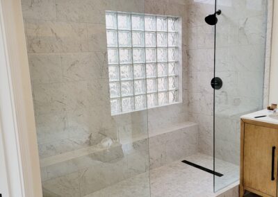 “Frameless clear glass shower screens installed side by side with an open center entry by A Cut Above Glass in Scottsdale, AZ.”
